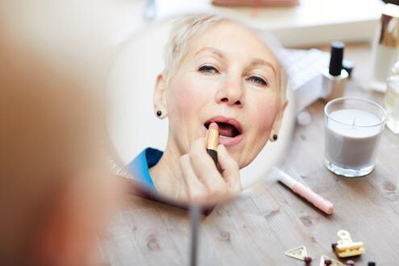 Woman putting Lipstick on