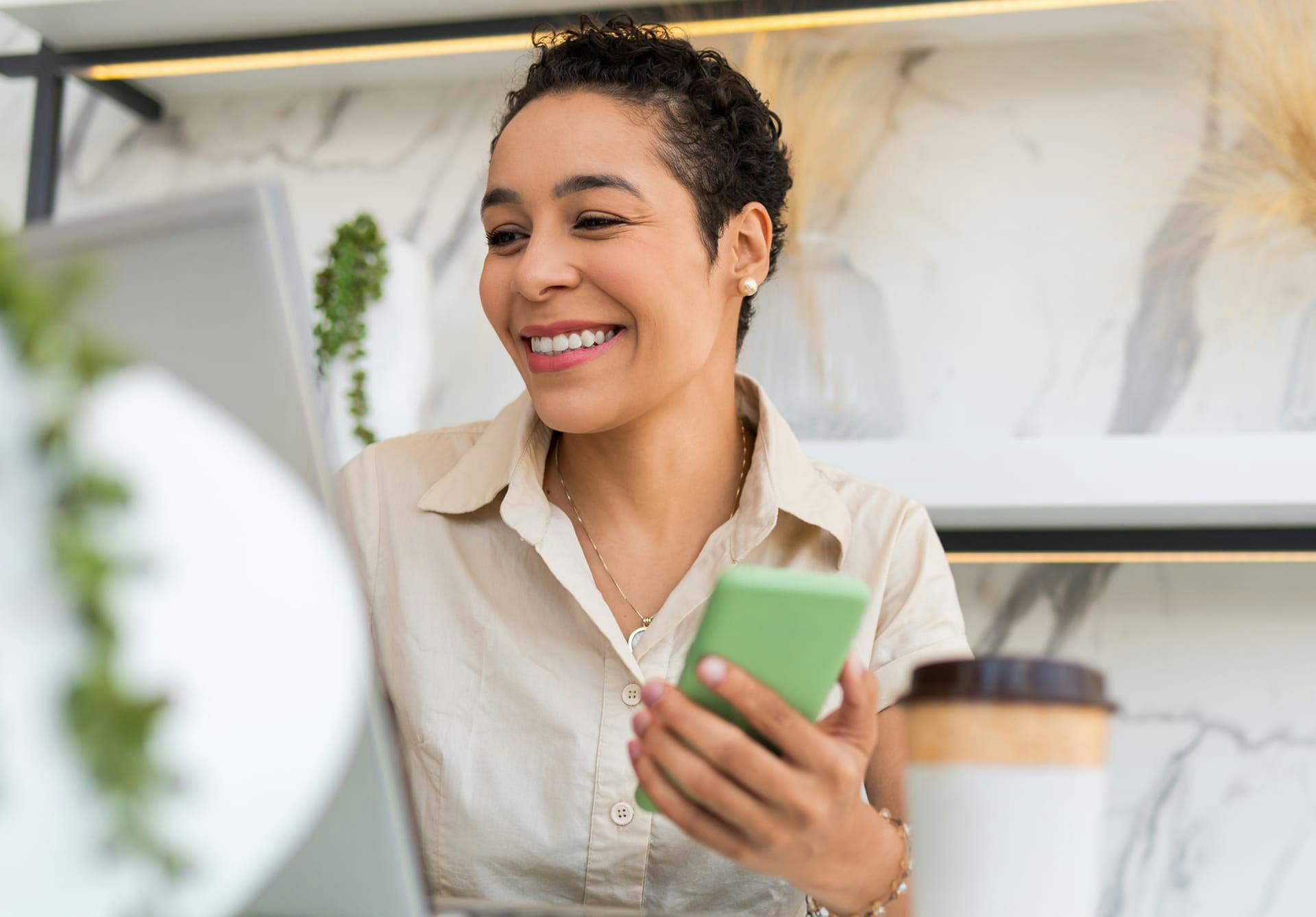 woman on laptop and phone smiling