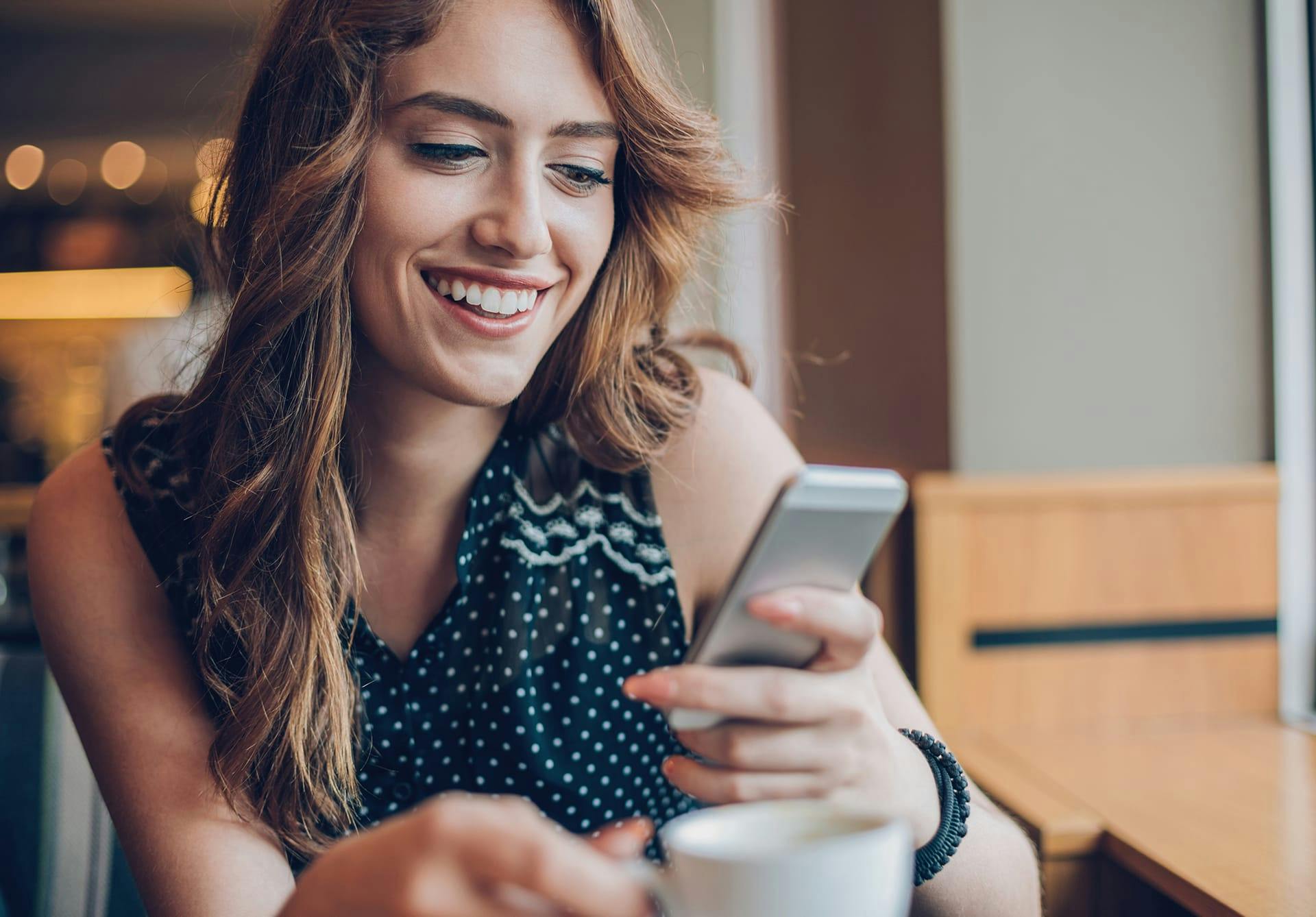 Woman smiling while looking at her phone