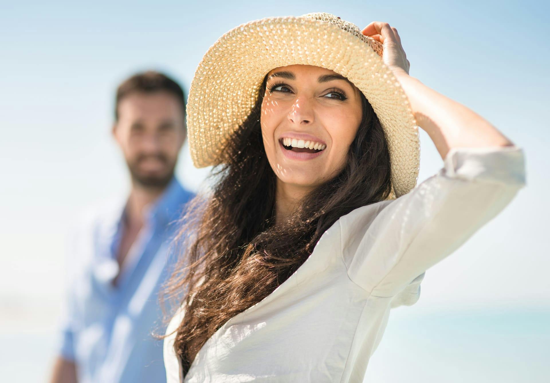 woman at the beach wearing a sunhat
