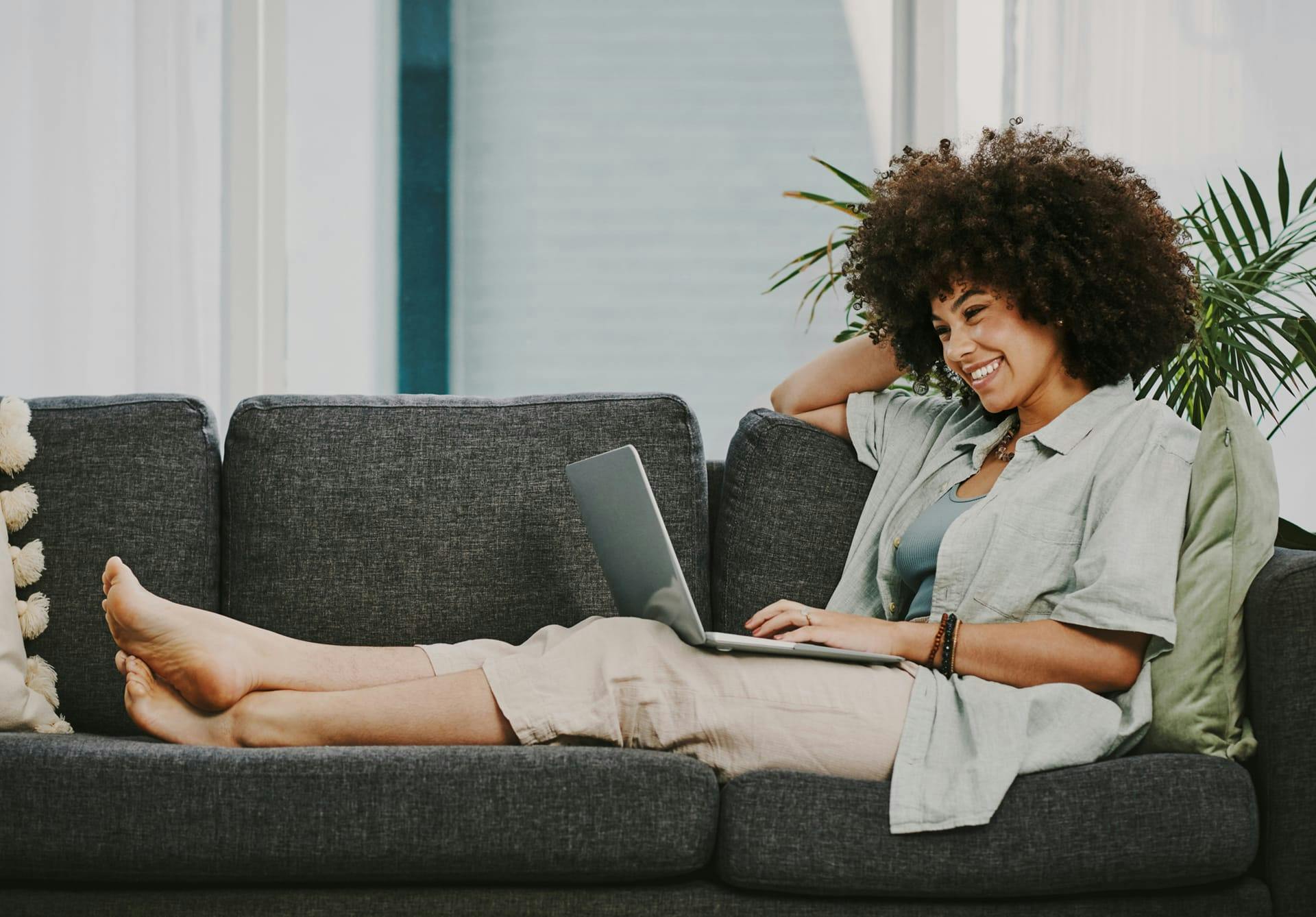 woman on couch on laptop smiling