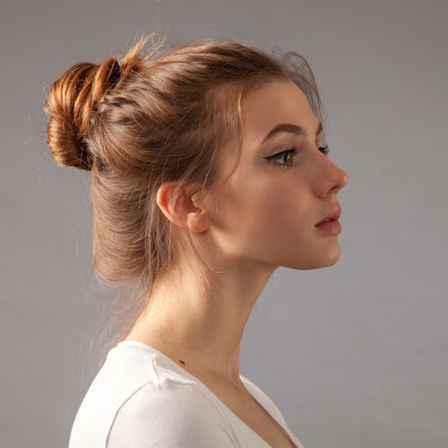 Side view of woman's face with her hair in a cute messy bun