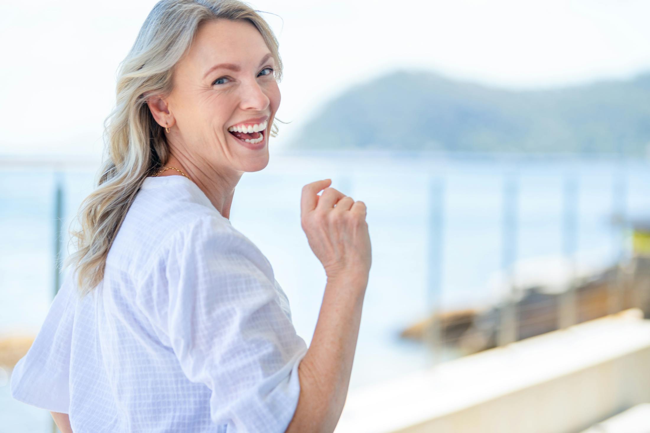 Woman in a white top smiling while walking