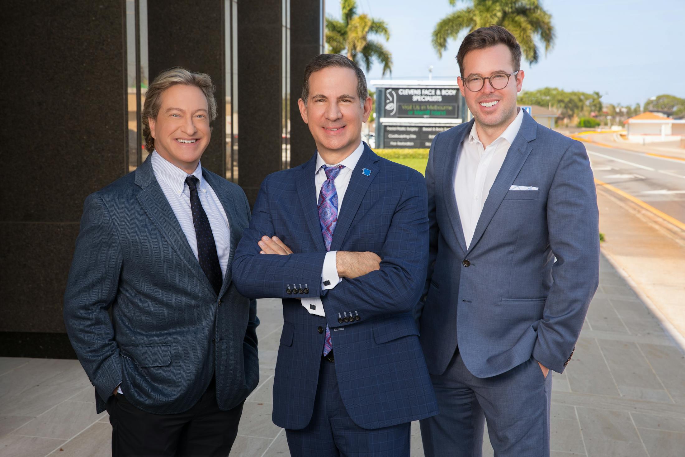 three doctors standing in their suits outside