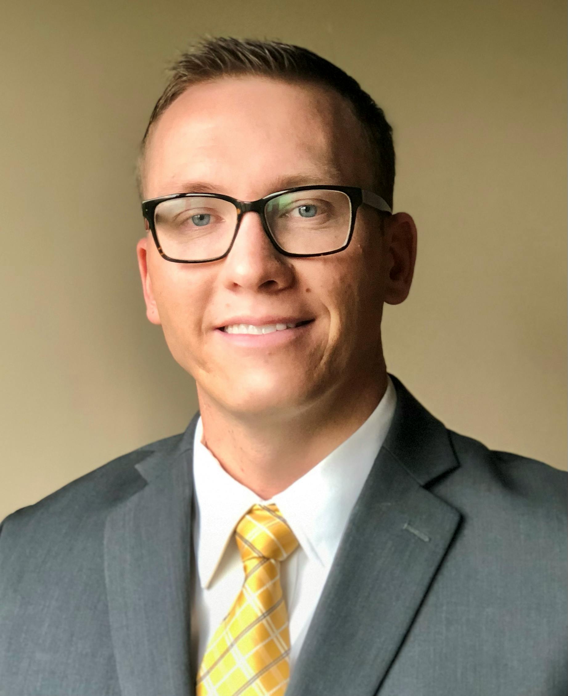 Dr. John Varner with glasses on and a suit