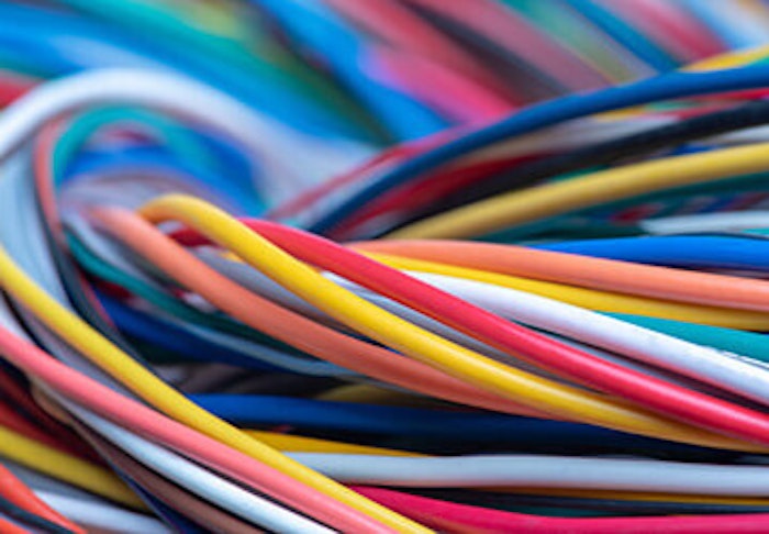 Bunte Stromkabel sind in verschiedenen Farben eng miteinander verwoben und bilden ein komplexes Netzwerk aus elektrischen Leitungen.