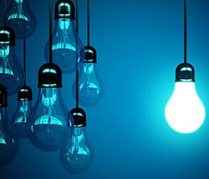 Eine Gruppe von nicht leuchtenden Glühbirnen hängt neben einer einzigen eingeschalteten Glühbirne, die ein helles, blaues Licht auf einem dunkelblauen Hintergrund ausstrahlt.