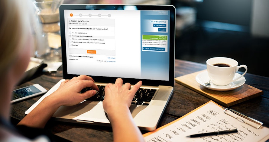 Eine Person arbeitet auf einem Laptop mit einer Lernplattform im Internet, während nebenbei ein Notizblock mit handschriftlichen Notizen, Stifte und eine Tasse Kaffee auf dem Tisch liegen.