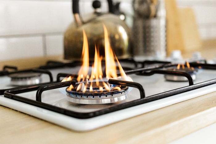 angeschalteter Gasherd mit hoher Flamme zum Wasserkochen in einer Küche