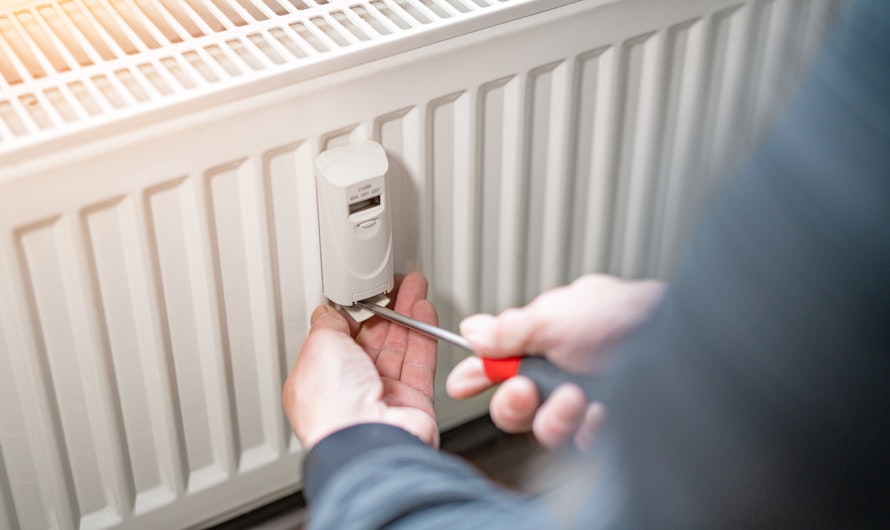 Ein Handwerker justiert mit einem Schraubendreher das Ventil eines weißen Heizkörpers, um die Wärmeleistung zu optimieren.