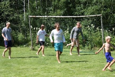 Panu Autio pelaa ilman kenkiä muiden lasten ja aikuisten kanssa nurmikentällä.