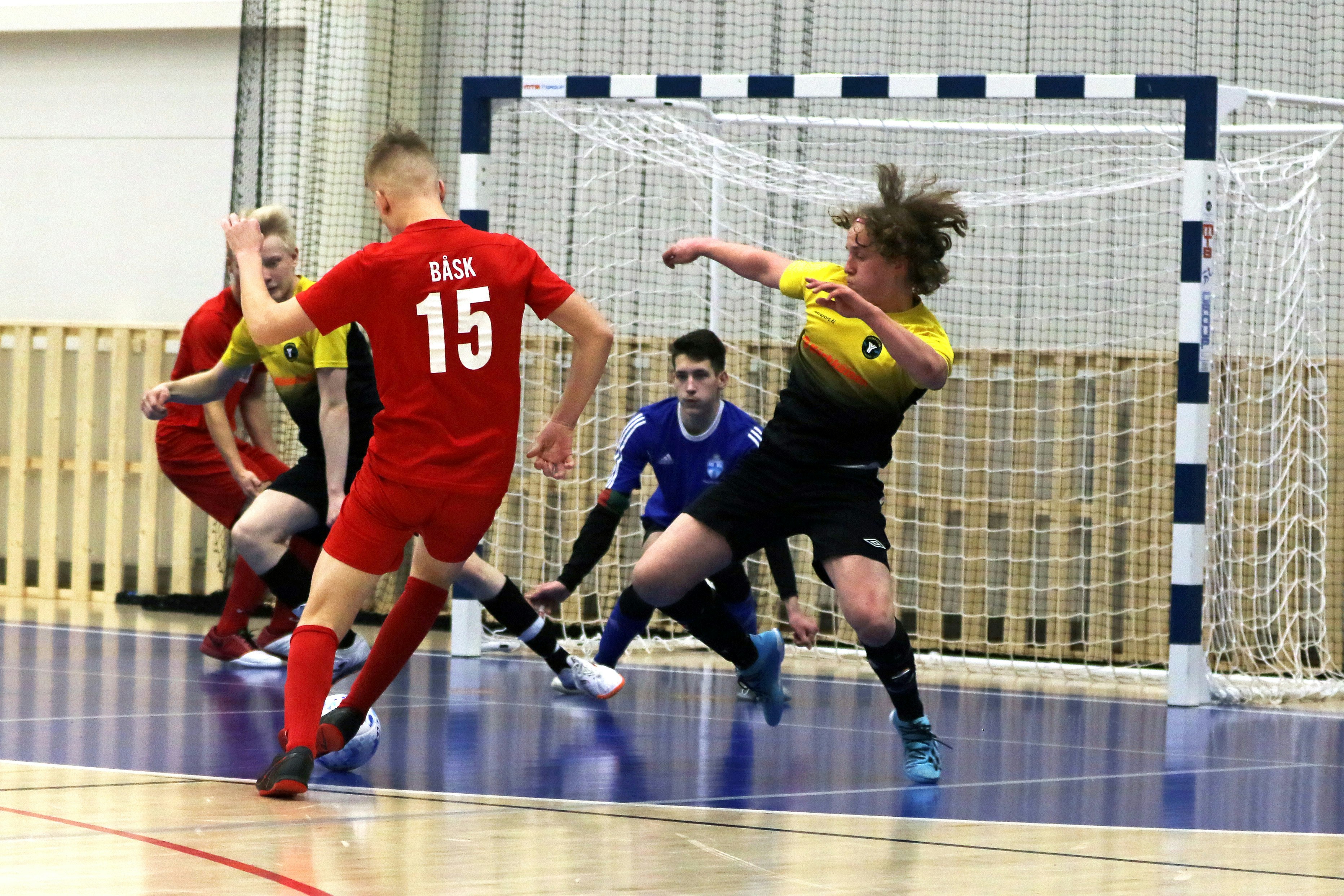 Futsalpelaaja laukomassa palloa.