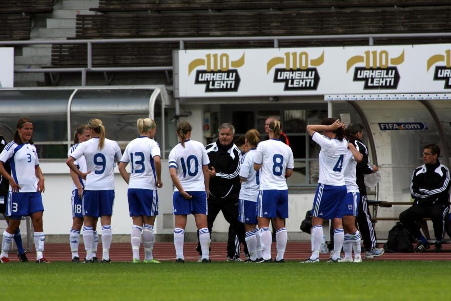 Suomen maajoukkue 2009 kotikisoissa, valokuvassa joukkue kuuntelee ohjeita valmentajalta