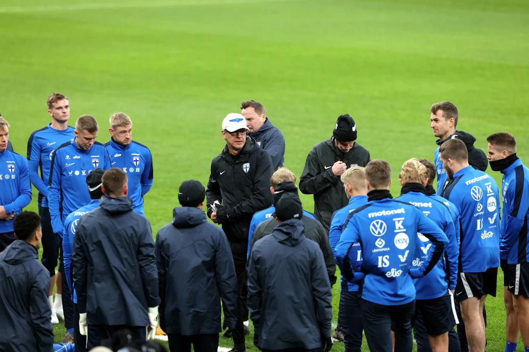 Päävalmentaja Markku Kanerva puhui joukkueelle tuulisella ja sateisella Parkenilla EM-avauksen aattona.