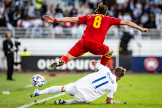 Rasmus Schüller liukuu palloon Nations League -ottelussa Montenegroa vastaan kesällä 2022.