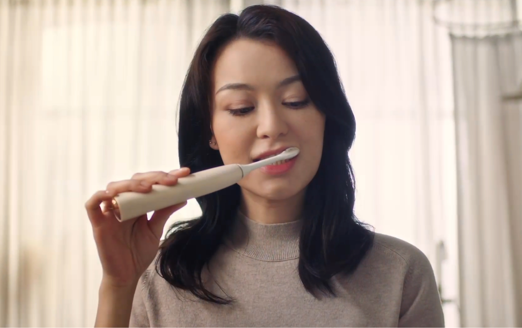 Woman brushing teeth with Philips toothbrush