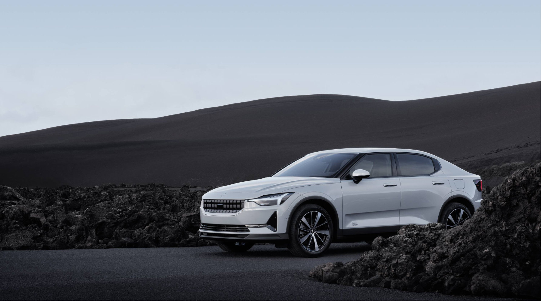 Polestar 2 driving in a hilly landscape.