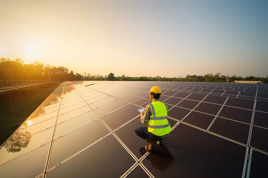 Handwerker auf Solarpanelen im Sonnenuntergang