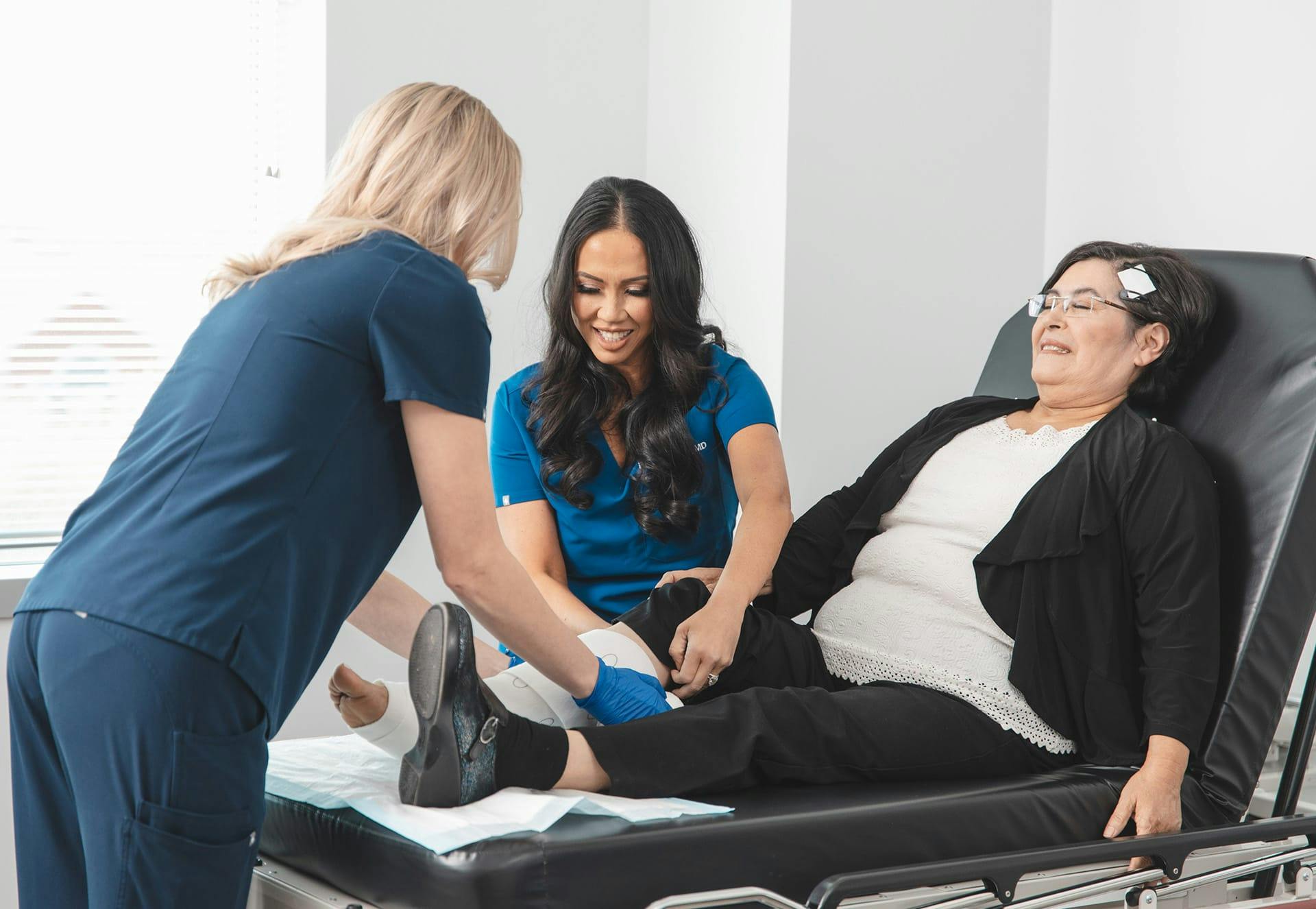 Two nurses working with a patient