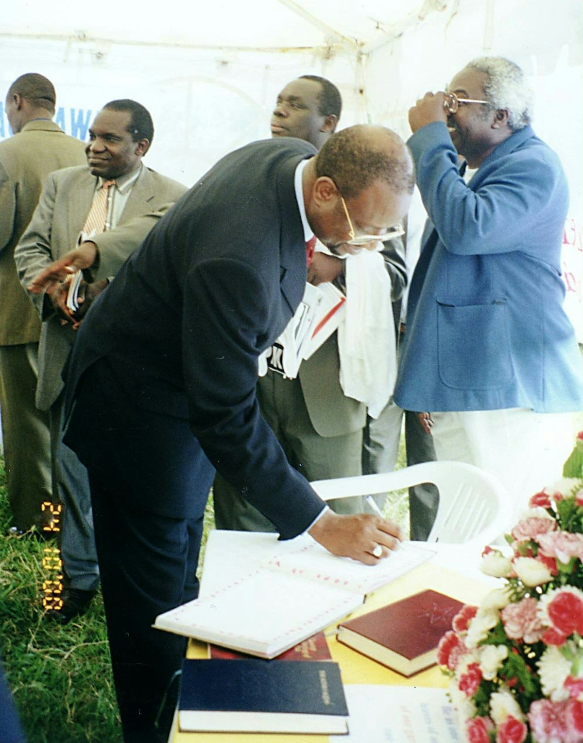 Mr. Dauda Toure, United Nations Resident Coordinator, signs the Guest Book in the Baha'i exhibit at Uganda's national United Nations Day commemoration.