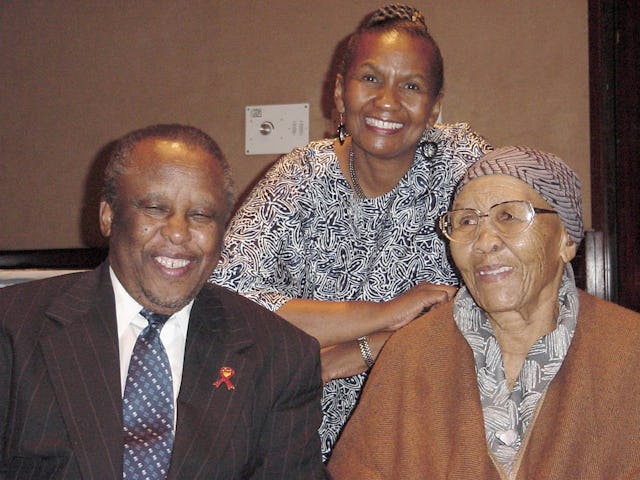 President Mogae of Botswana with two of the translators who produced selections from the Baha'i scriptures in the native Setswana language.| Left to right: President Mogae, Lally Warren, and her mother, Stella Moncho. Mrs Moncho is nearly 92 years old; she and her late husband were the first Baha'is of Botswana.