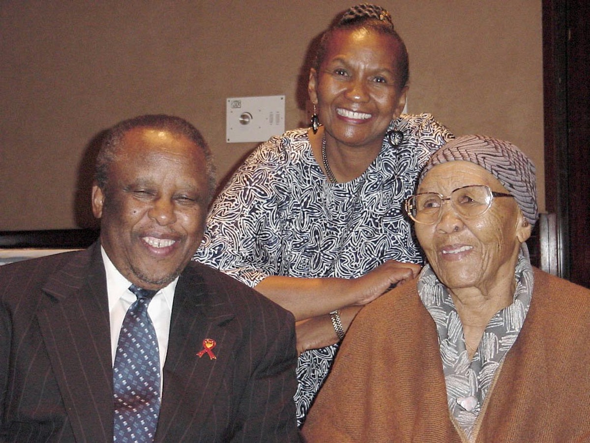 President Mogae of Botswana with two of the translators who produced selections from the Baha'i scriptures in the native Setswana language.| Left to right: President Mogae, Lally Warren, and her mother, Stella Moncho. Mrs Moncho is nearly 92 years old; she and her late husband were the first Baha'is of Botswana.