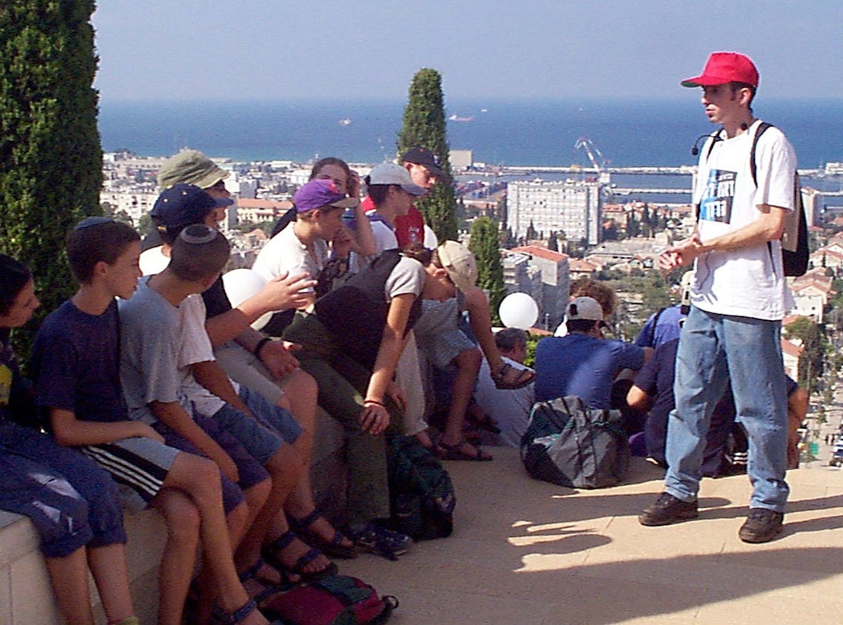 Tour guide Yohai Devir, a student at Haifa's Technion university, takes questions from tour participants while pausing on a terrace below the Shrine of the Bab.