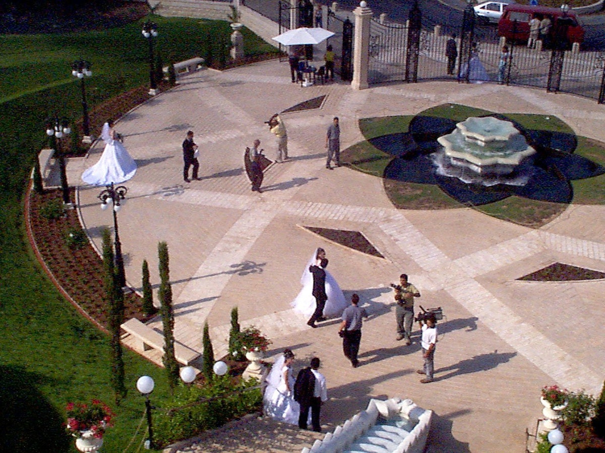 Three newlywed couples have their wedding photos taken on the entrance plaza of the Baha'i Terraces on Mount Carmel, a practice that has become very common among newlyweds in Haifa.