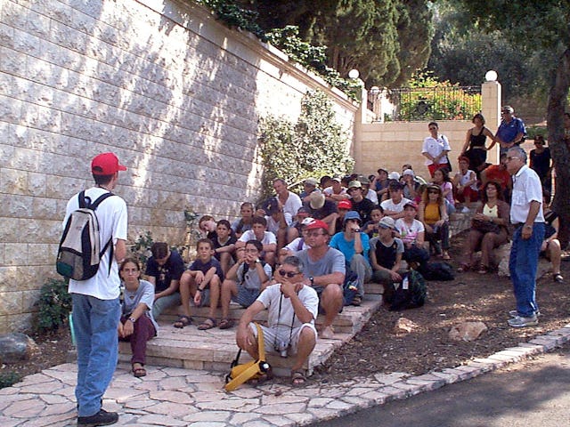 A group of tourists listens to an explanation of the history of the Shrine of the Bab during a guided tour of the Baha'i Terraces on Mount Carmel.