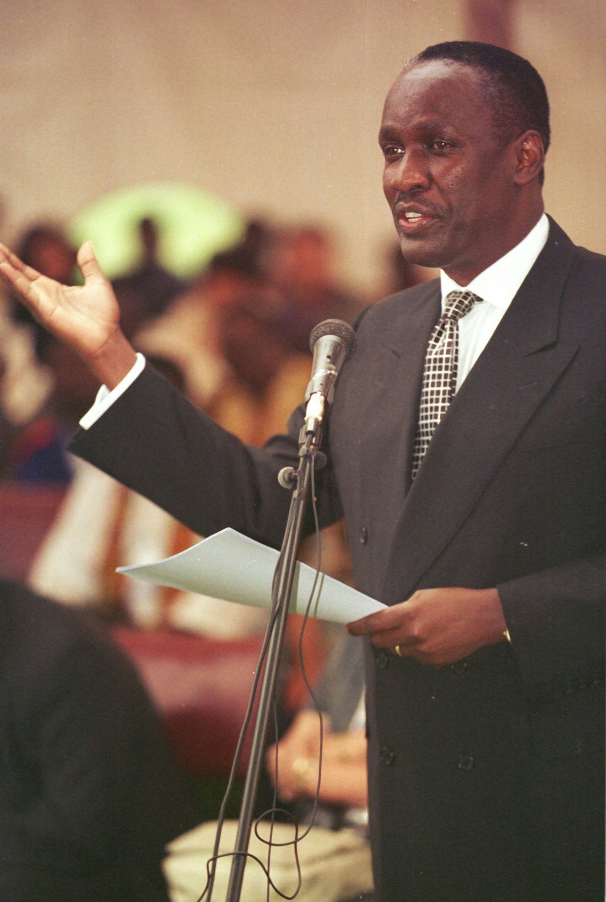 Captain Michael Mukula, Uganda's State Minister for Health, reads a statement from the President Yoweri Kaguta Museveni at a commemoration of the 50th anniversary of the Baha’i community of Uganda, held at the Baha’i House of Worship near Kampala on 2 August 2001. (Photo: Ryan Lash)