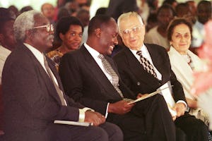 Mr. Ali Nakhjavani (third from left) speaks with Captain Michael Mukula, Uganda's State Minister for Health, at a commemoration of the 50th anniversary of the Baha’i community of Uganda held 2 August 2001 at the Baha’i House of Worship near Kampala. Mr. Nakhjavani, a member of the Universal House of Justice, was one of the six Baha’is who founded the Baha’i community in Uganda in 1951. (Photo: Ryan Lash)