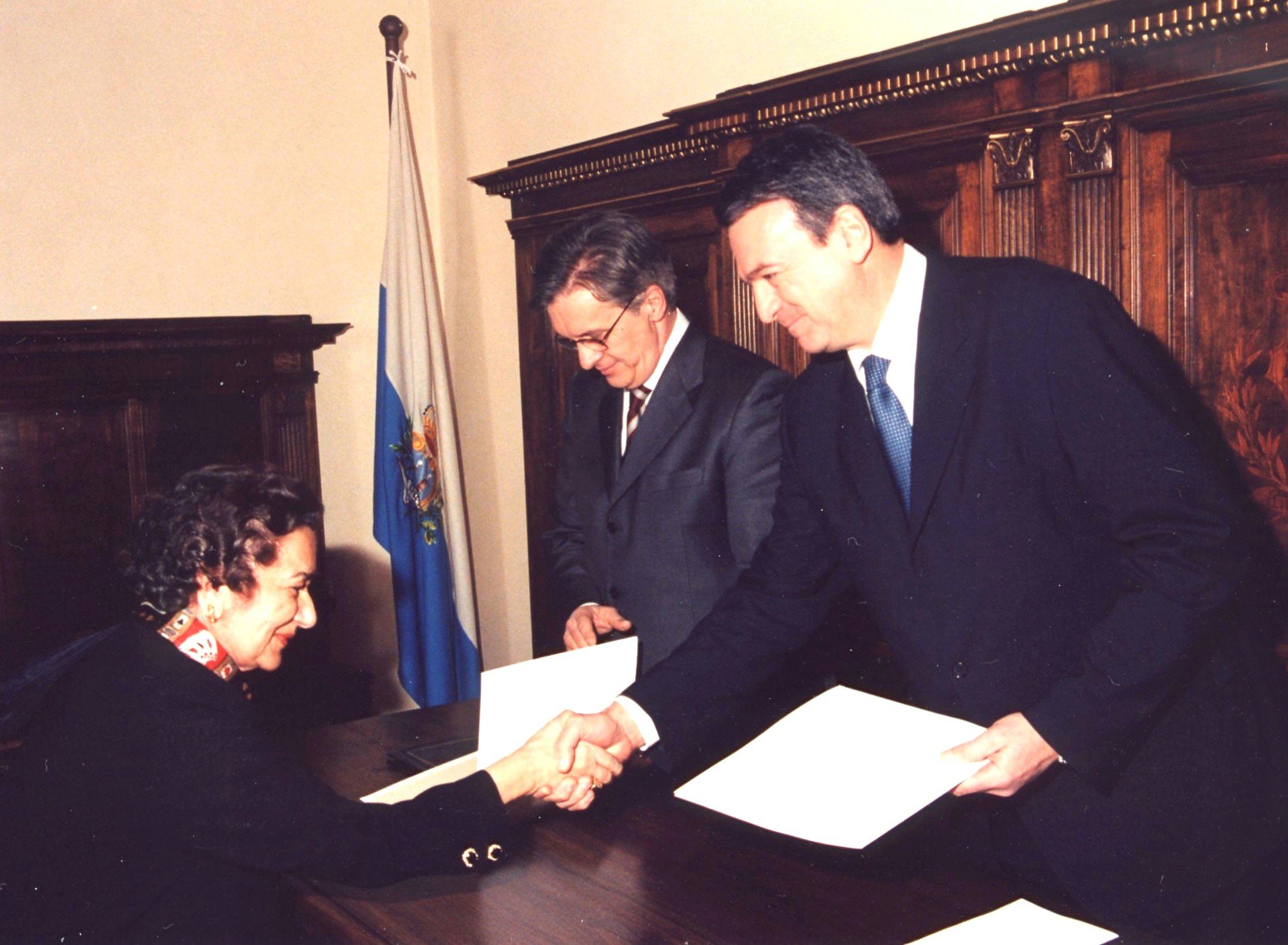 The message of the Universal House of Justice is delivered to the Captains Regent of San Marino, Mauro Chiaruzzi (left) and Mr. Giuseppe Maria Morganti, by Mrs. Tabandeh Payman.