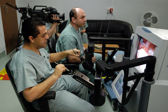 Dr. Mehran Anvari, left, using a specialized robot performs an historic operation via telerobotics. (Courtesy St. Joseph's Healthcare)