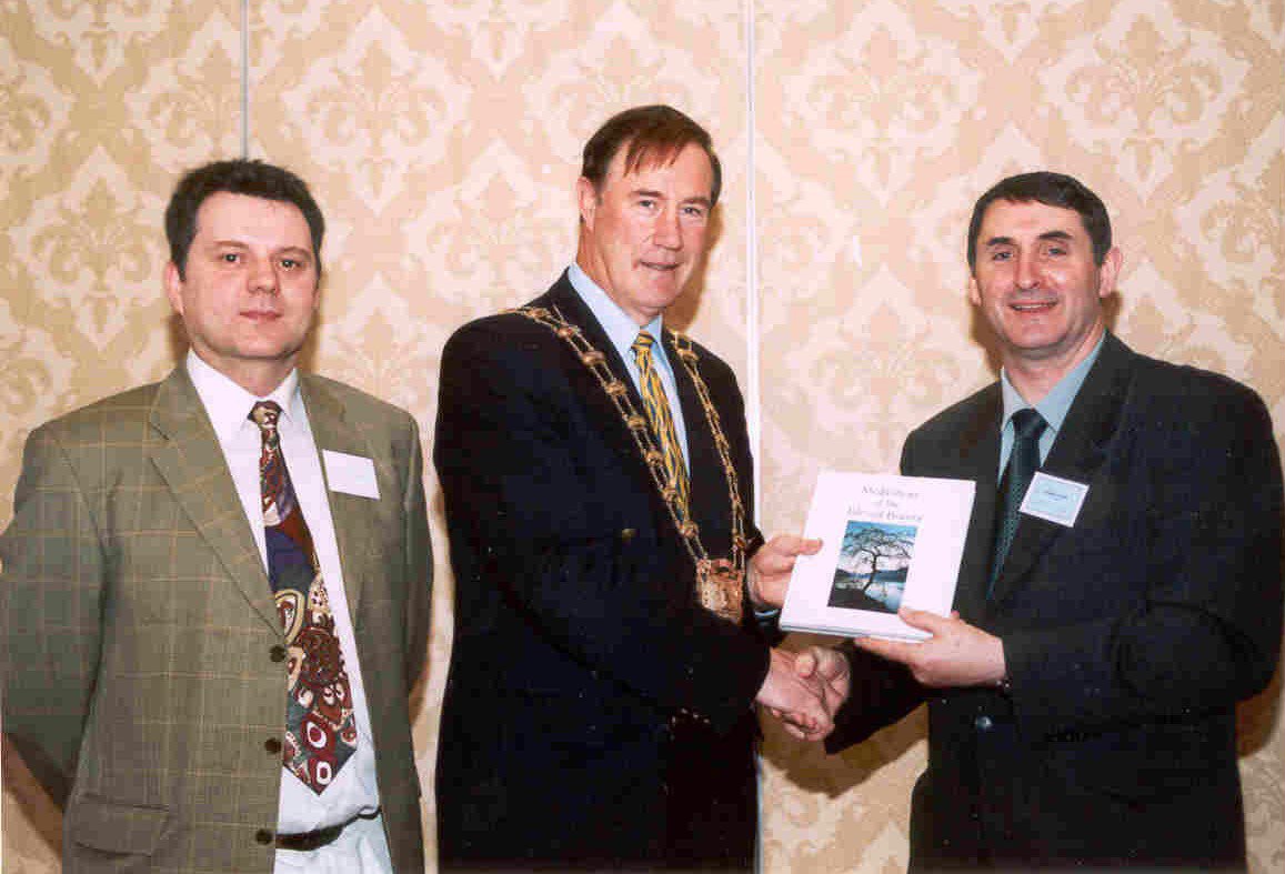 Ireland: Mr. Michael Kennedy, chairman of Fingal County Council, is presented with Baha'i literature by Mr. Ray Maloney (left) and Mr. Brendan McNamara (right with book) at the Baha'i National Convention. (Photo: Astrid Steffens)