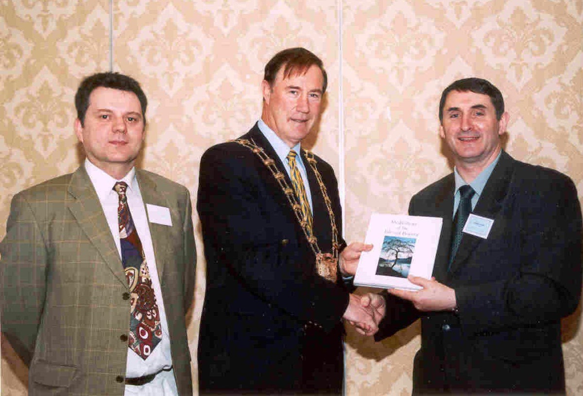 Ireland: Mr. Michael Kennedy, chairman of Fingal County Council, is presented with Baha'i literature by Mr. Ray Maloney (left) and Mr. Brendan McNamara (right with book) at the Baha'i National Convention. (Photo: Astrid Steffens)