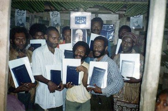 Holding a precious gift...Baha'is at the Kiniving Centre with the Kitab-i-Aqdas.