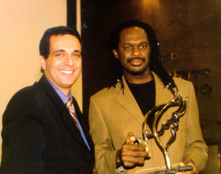 Silvio Humberto dos Passos Cunha (right), from the Steve Biko Benefactor Institute, accepted an award from Baha'i representative Roberto Iradj Eghrari.