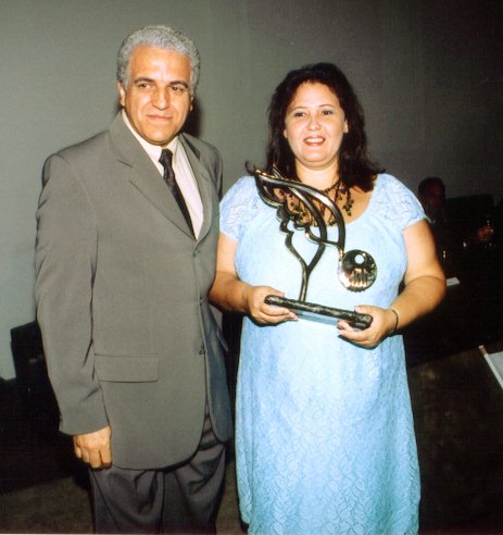 Baha'i representative Carlos Alberto Silva presents an award to Bernardete Ferreira of March Eighth Woman's House.