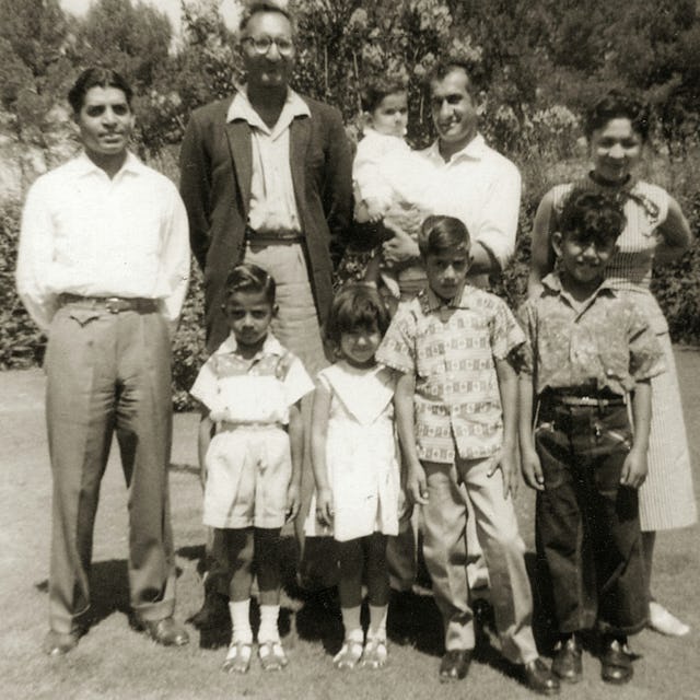 The first South African Indian to become a Baha'i was Dr. Abdul-Hak Bismillah (holding baby) in 1955. He is pictured with his wife, Joan. They are with Sombi Govind (left), Ismail Cassim and children.