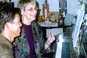 Choir members Bonnie Ellis (right) and Noly Parocha rehearsing a song.