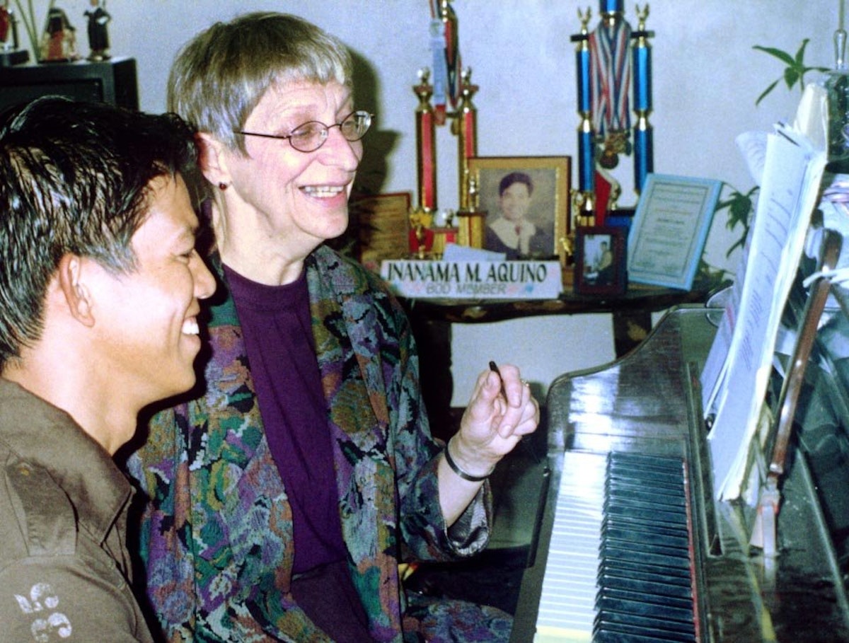 Choir members Bonnie Ellis (right) and Noly Parocha rehearsing a song.