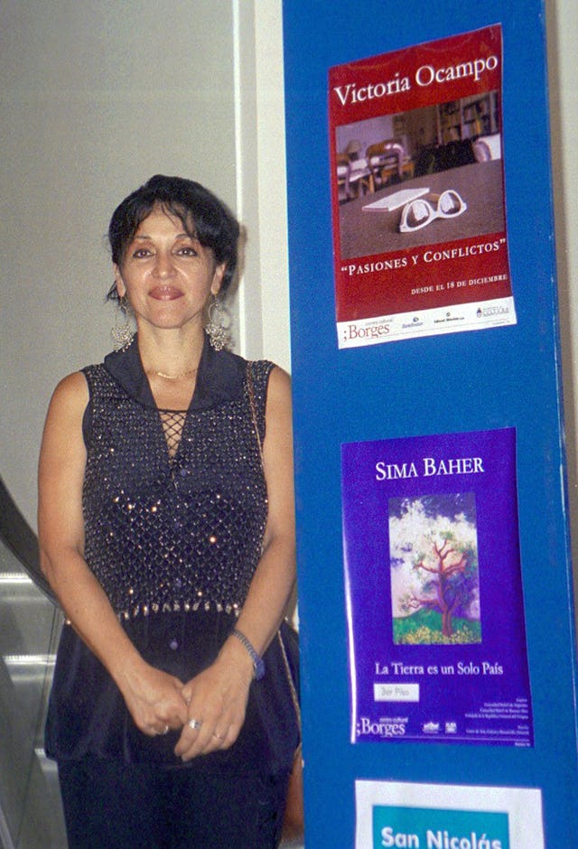 Sima Baher beside the poster of her exhibition at the Borges Cultural Center in Buenos Aires.