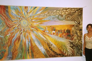 Sima Baher with her mural "The Dawn of a New Era."