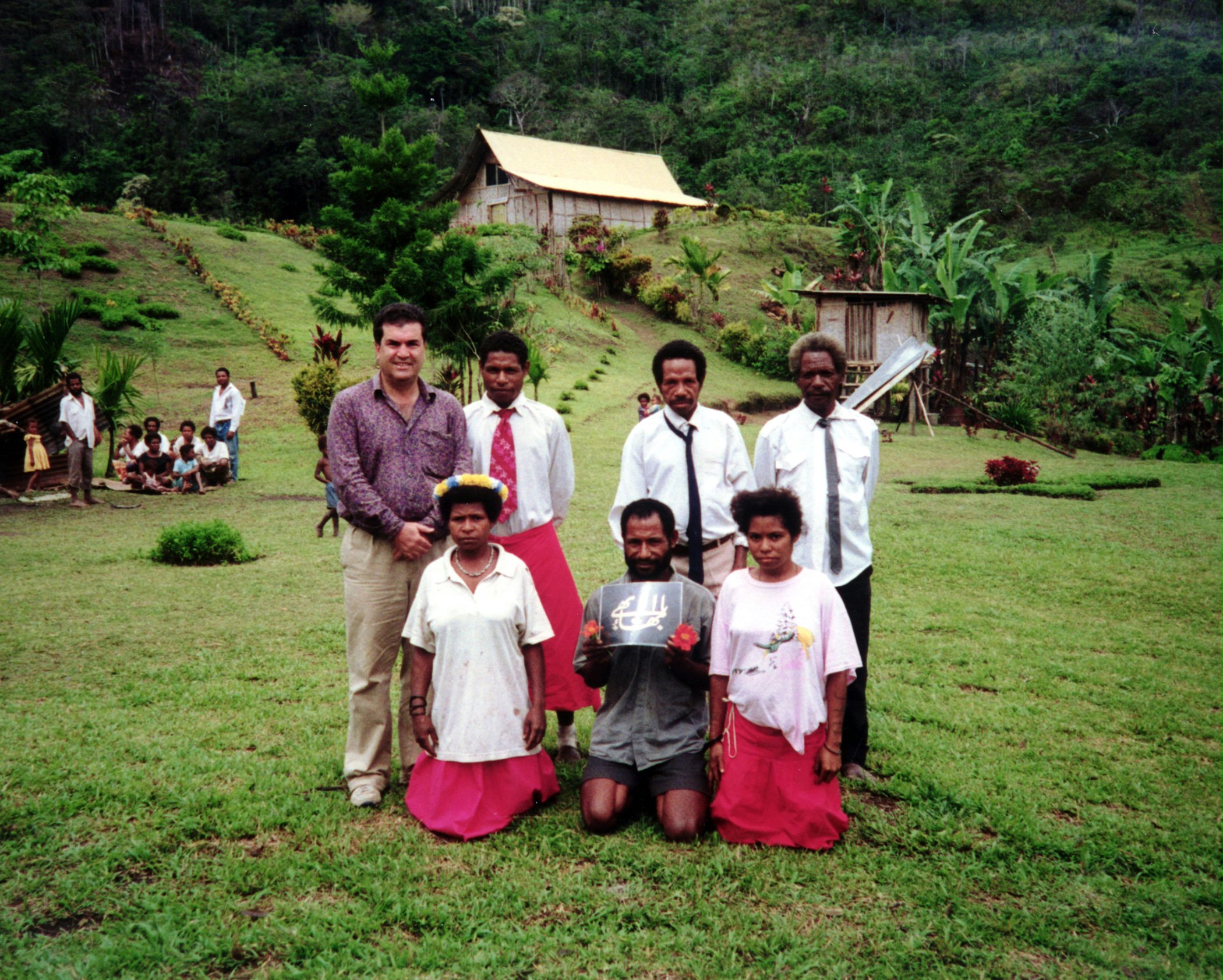 Local Baha'is meet with Sirus Naraqi (left, rear), a member of the Continental Board of Counsellors for Australasia, at their village in Papua New Guinea.