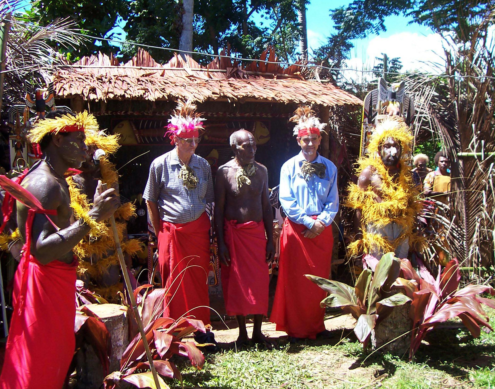 Tamun Kosep, a traditional chief and treasurer of the first Local Spiritual Assembly of Madina, (center), flanked by Rodney Hancock (left), and Jalal Mills, with other Baha'is at the jubilee festivities.