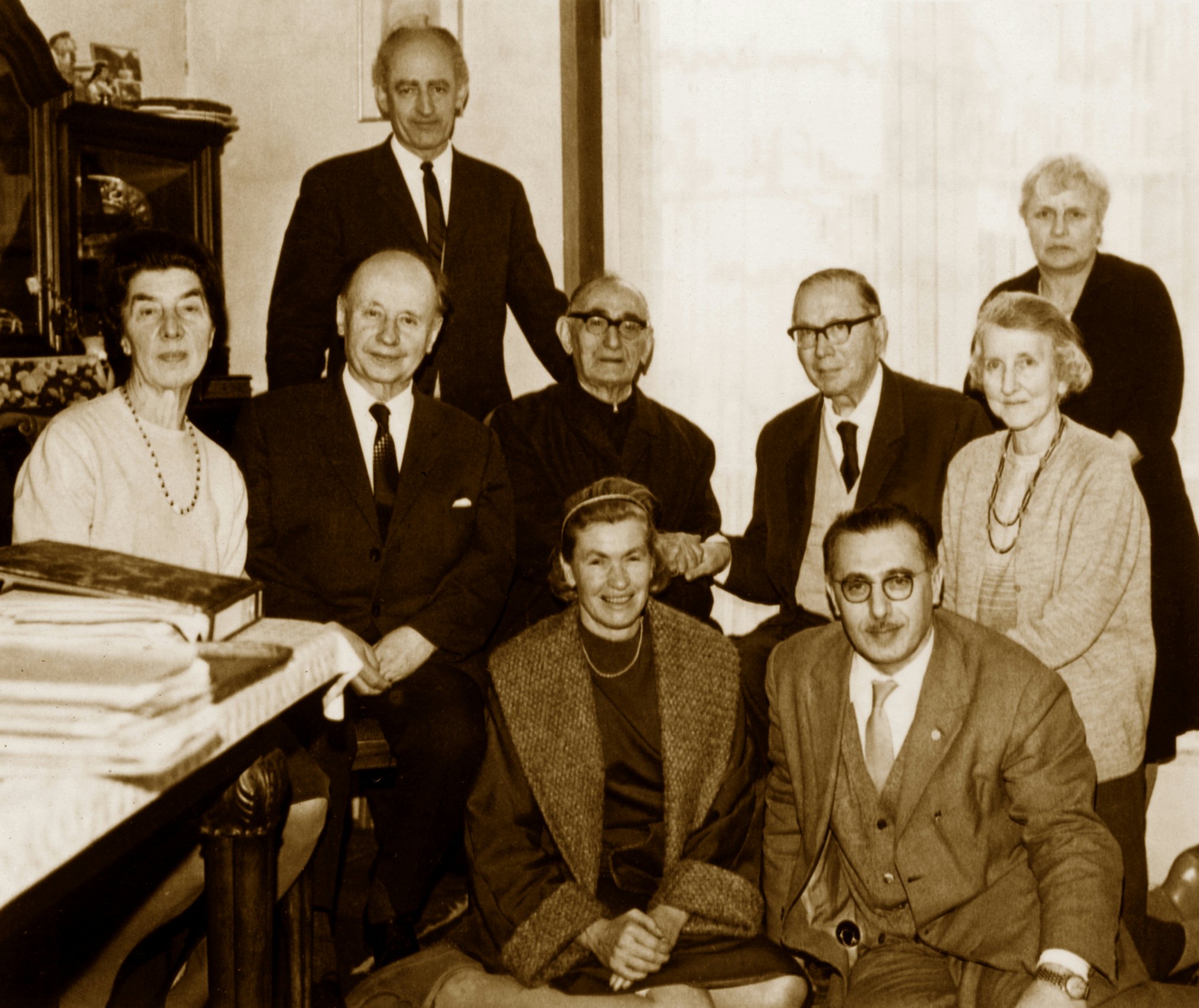 Erik Blumenthal (standing left) with esteemed company. (Second row seated, left to right): Mrs. Anna Grossmann, Hand of the Cause Dr. Adelbert Muhlschlegel, Hand of the Cause Tarazu'llah Samandari, Hand of the Cause Dr. Hermann Grossmann, Elsa Maria Grossmann (sister of Dr. Grossmann). (Front row seated, left to right): Mrs. Annaliese Bopp and Dr. Mehdi Samandari. (Standing at right) Mrs. Dorothy Ferraby. At the home of Dr. and Mrs. Grossmann, March 14, 1968.