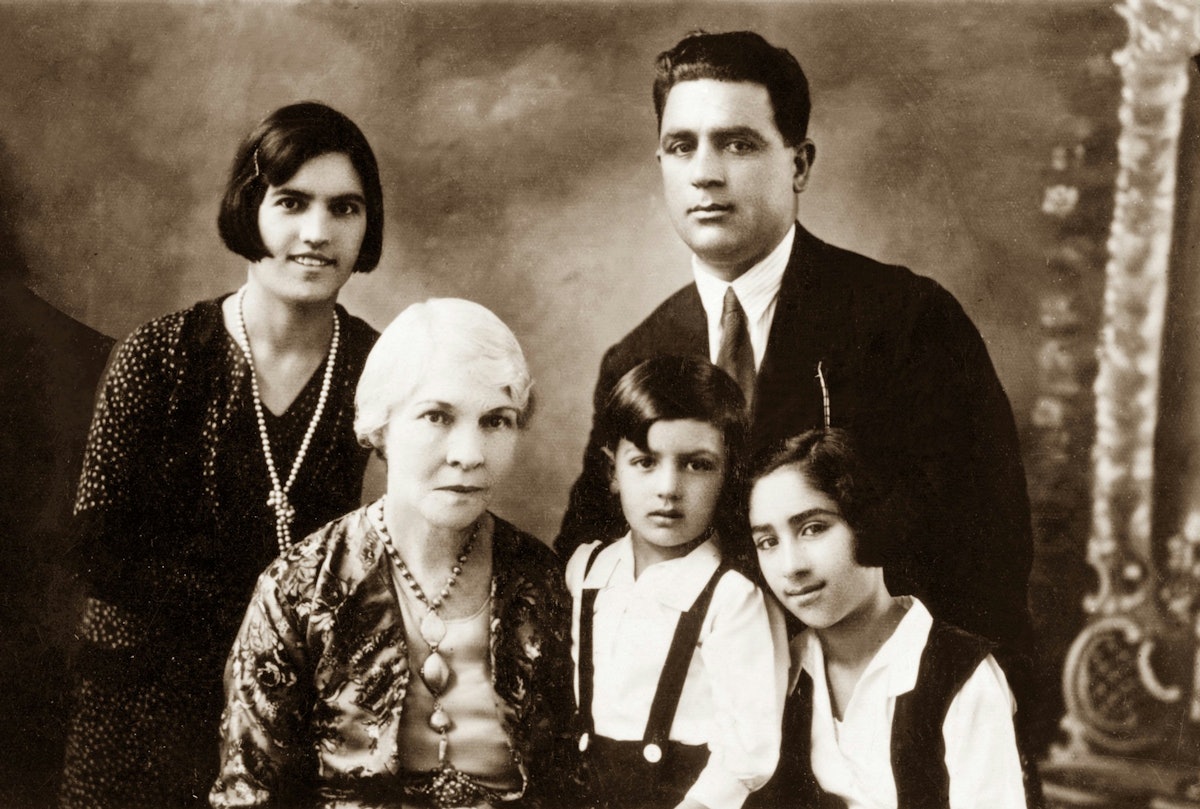 Hand of the Cause Keith Ransom-Kehler (seated at left) and the parents of Gloria Faizi, Rahmatu'llah Khan 'Ala'i (standing at right) and Najmieh (standing at left), with Gloria (right) and her brother, Manuchihr.