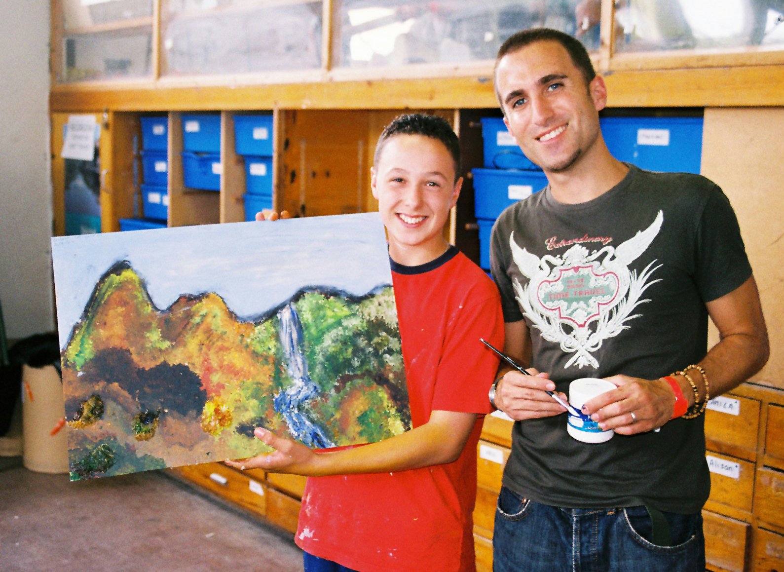 Neisan Dehghani, 13, (left) shows the fruit of his painting class with tutor Payam Beint (right).