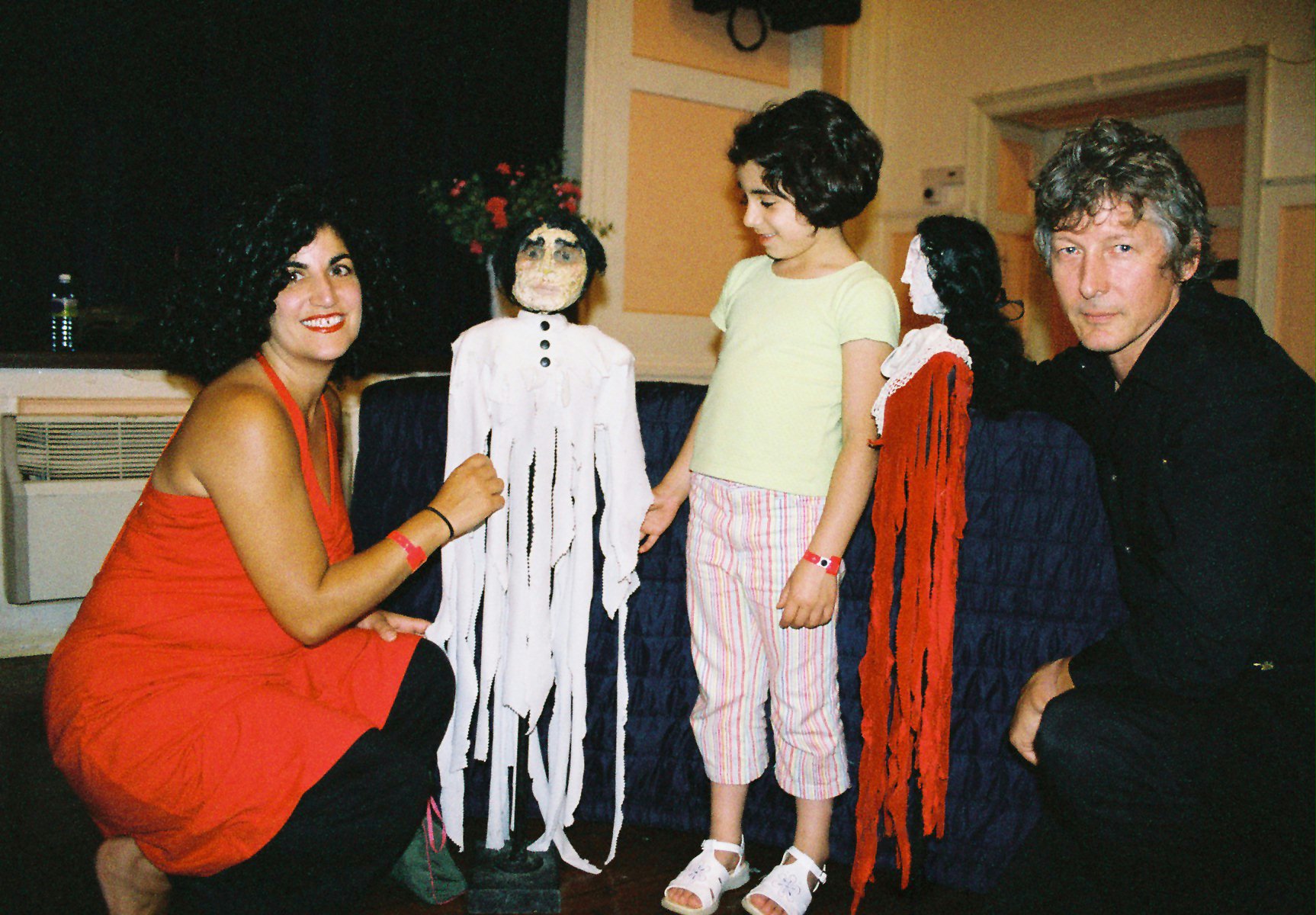 Theater artist Bill George (right) and actor Shirin Youssefian-Maanian (left) show puppets to a young participant.