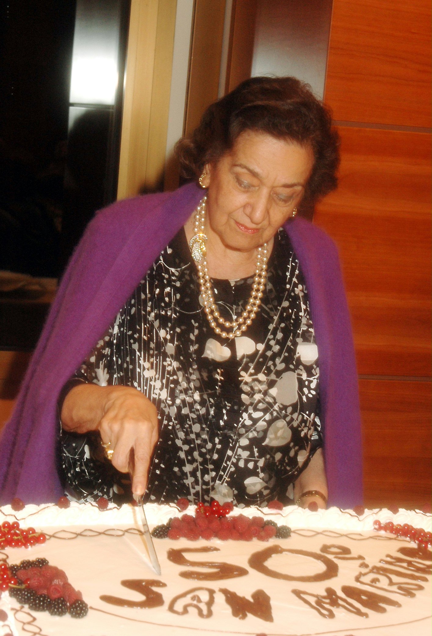 Golden jubilee of the Baha'i community of San Marino...Tabandeh Payman cuts the birthday cake.
